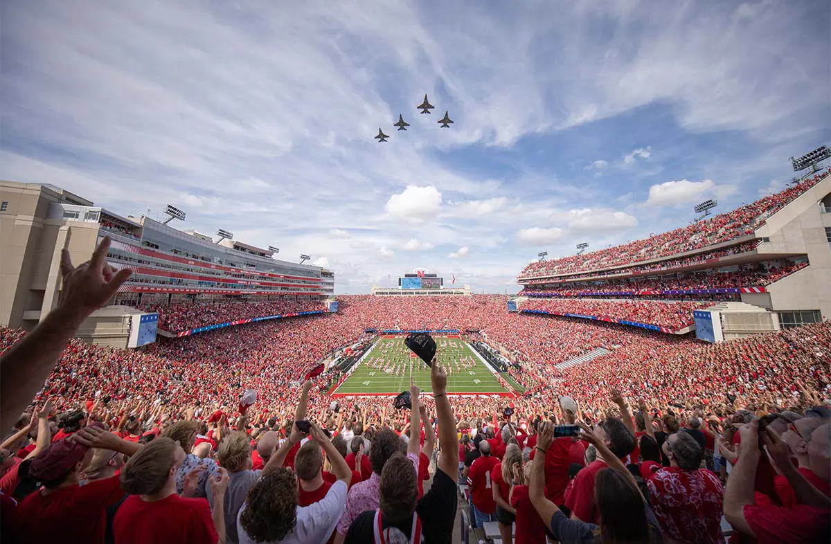 Aerial view of full football stadium with jets flying overhead